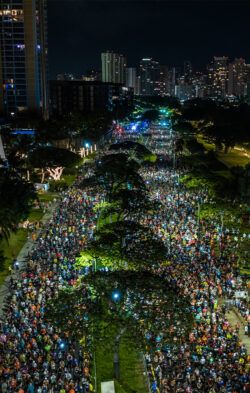 A Busy start line in the dark, lit up by street lights
